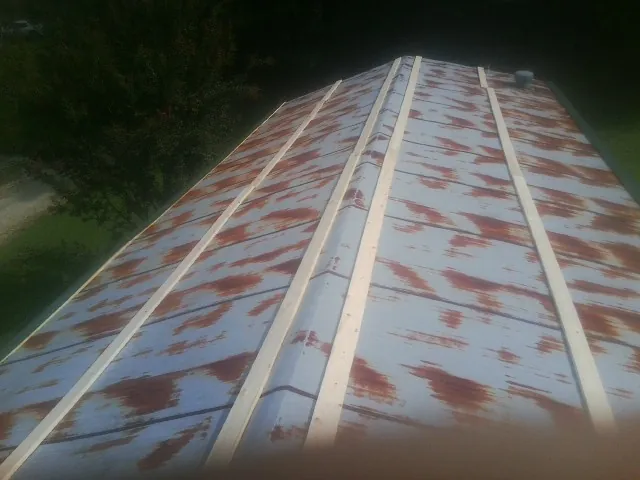 Rusted metal roof panels with new wood purlins before replacement — Storm Damage Roof Repair in Deridder by Roofing Brothers