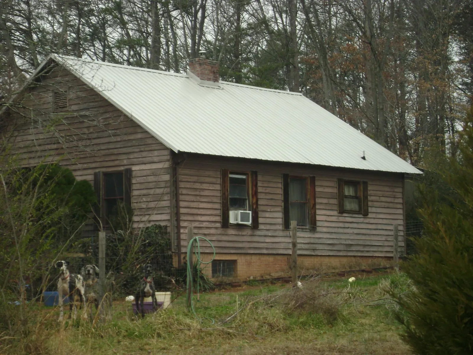 White metal roof on an old wood sided farmhouse, from a Metal Roof Installation job in Deridder